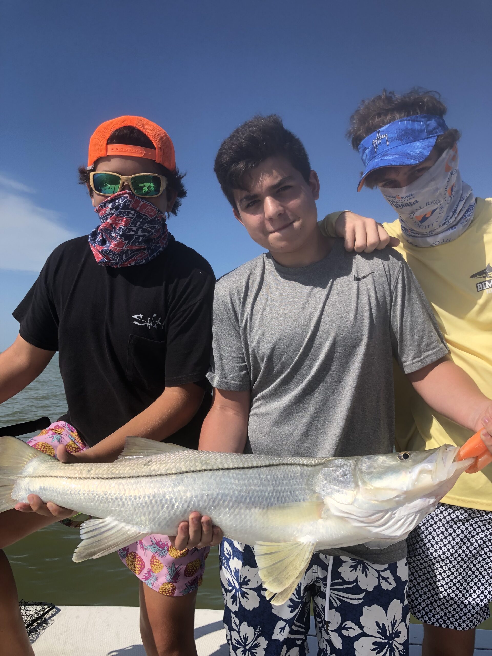 Three boys holding a snook. Opens a photo gallery.